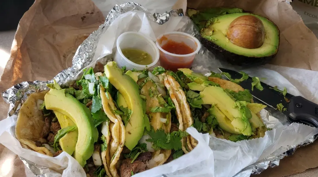 La Perla tacos topped with avocado slices