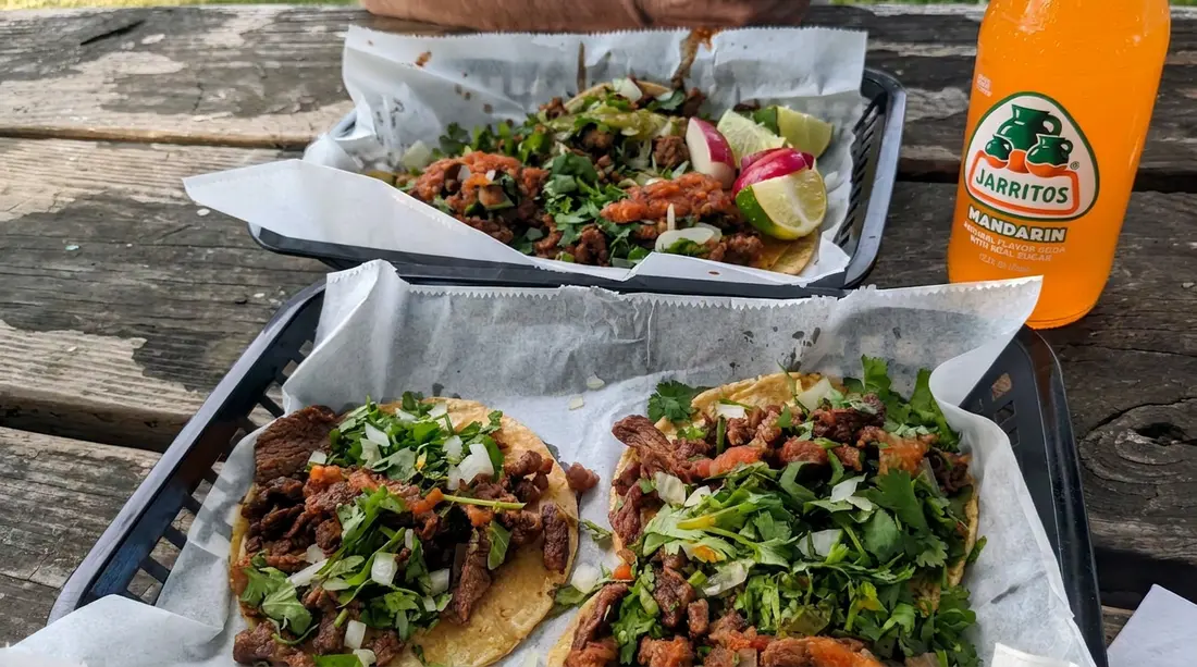 La Perla tacos served on plates at an outdoor table