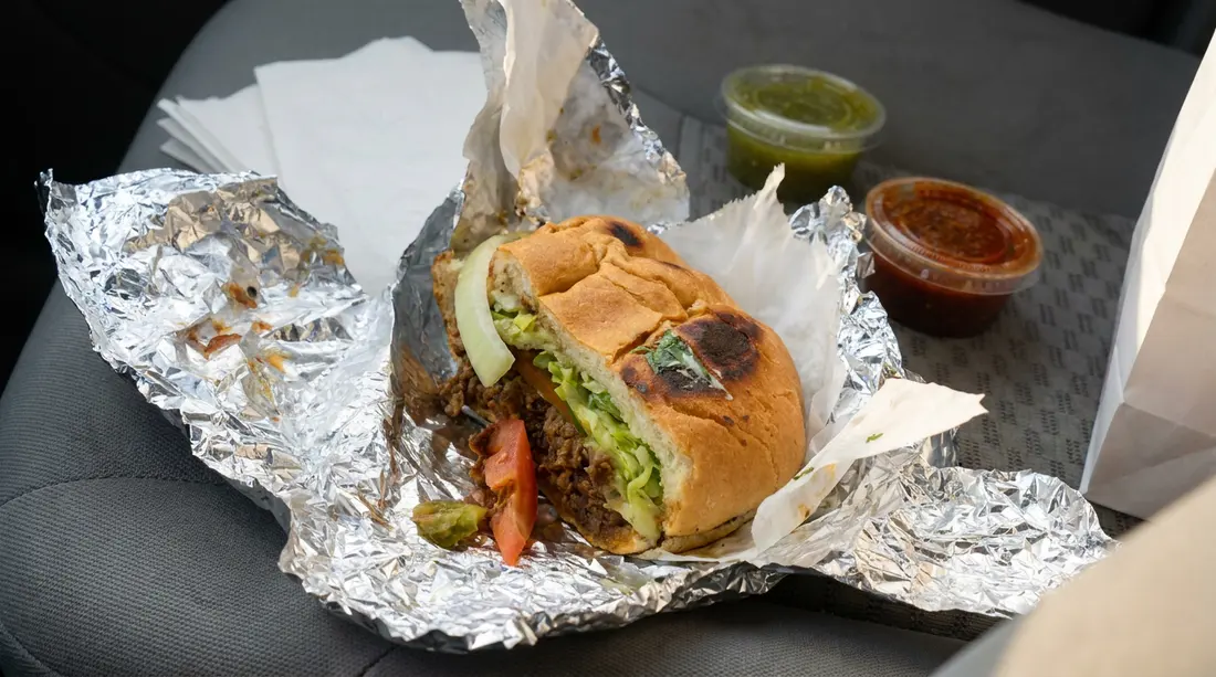 Mexican sandwich filled with grilled meat and vegetables
